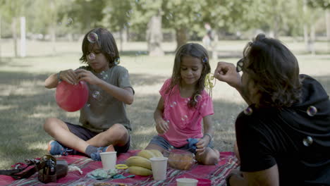 Family-having-picnic-in-public-park-on-summer-day